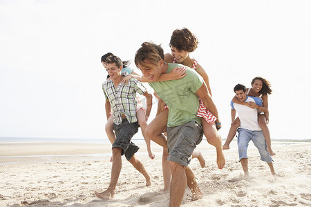 一群朋友一起沿着海滩奔跑