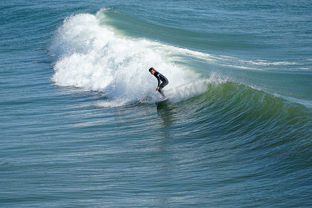 在美国加利福尼亚州圣地亚哥北部的欧申赛德享受巨浪的男性冲浪者。