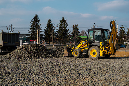 乌克兰，卢茨克 — 2020 年 4 月 10 日：黄色轮式装载机挖掘机在施工现场用砾石作业。