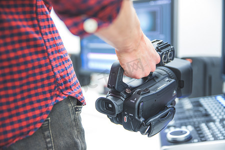 专业电影制作：男性电影制作人正在用专业电影摄影机录制。