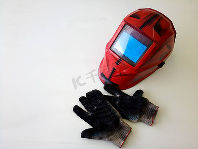 焊接工人摄影照片_肮脏的焊接手套的照片，焊工的面具在车间。您的文本的空间。