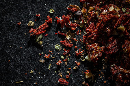 食品香料摄影照片_干番茄和辣椒特写在豪华的石头背景上，作为平铺、干食品香料和配方成分