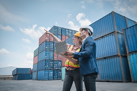 进出口运输行业的集装箱航运物流工程、运输工程师团队合作在港口装船码头控制管理集装箱。