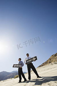 两个商人在沙漠中举着单向标志