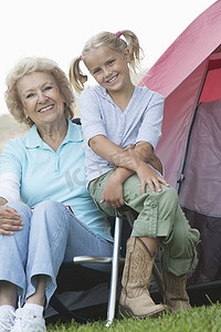 祖母和孙女坐在帐篷外