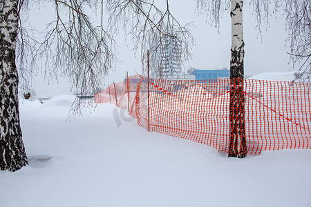 下雪安全摄影照片_建筑工地的塑料红色安全网。