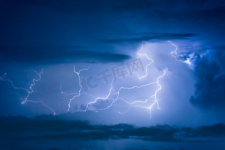 雷阵雨摄影照片_雷暴雷击在夜间乌云密布的天空背景上。