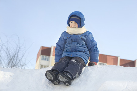 坐在雪地里的小男孩