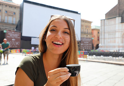 意大利户外咖啡馆里微笑美女的画像，喝咖啡