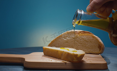 将橄榄油倒在面包片上