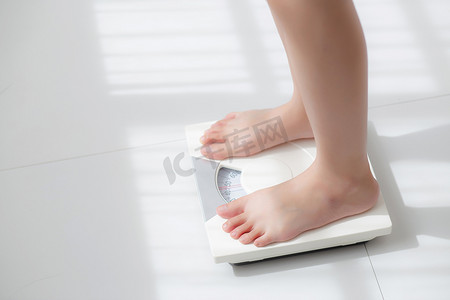 减肥名片摄影照片_生活方式活动，女性站腿测量赤脚饮食体重秤，女孩苗条减肥措施的特写脚，用于食品控制和营养、健康护理和健康概念。