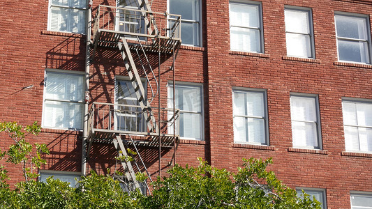 建筑消防摄影照片_美国圣地亚哥市住宅砖砌建筑外的消防梯。