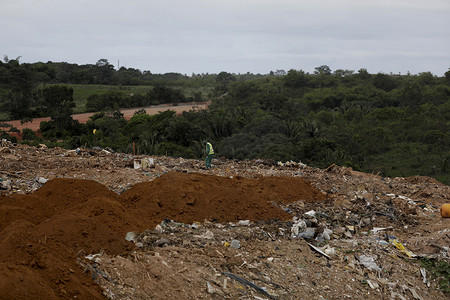 垃圾填埋摄影照片_卡车将垃圾存放在萨尔瓦多市的垃圾填埋场