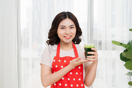 健康减肥享受生活摄影照片_年轻的亚洲女性享受健康的素食冰沙来减肥和排毒