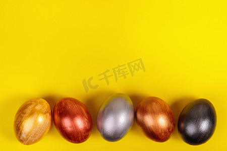 统一黄色背景上的多色鸡蛋，带有文本位置。