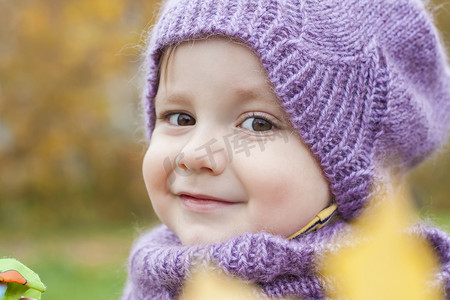 一个戴着紫色针织帽子和围巾的孩子。