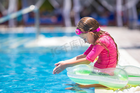游戏娱乐摄影照片_在室外游泳池玩得开心的微笑可爱女孩