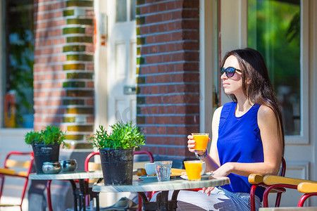 坐在欧洲城市户外咖啡馆吃早餐的美女