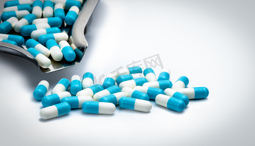 白色背景上的蓝色和白色胶囊药丸和药物托盘，带有文本复制空间。