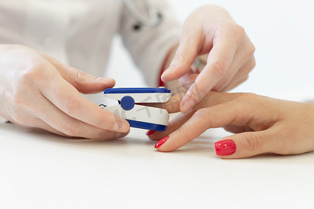 医生将心率监测器放在患者的手指上