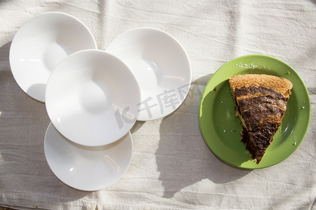 碟子俯视图摄影照片_白色碟子附近的巧克力海绵蛋糕片