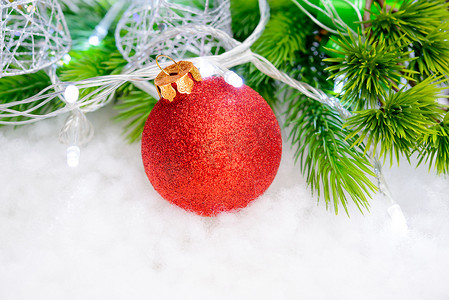 圣诞装饰与红球、 绿色冷杉分支和雪中的白灯。