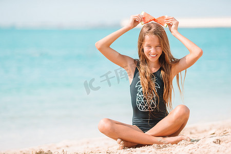 吃女孩西瓜摄影照片_暑假期间在海滩上逗人喜爱的小女孩