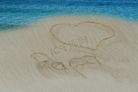 沙滩上用沙子画了一颗心和爸爸这个词。