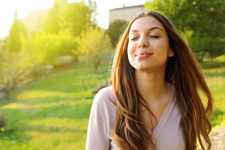 女人微笑着抬头深呼吸庆祝自由。