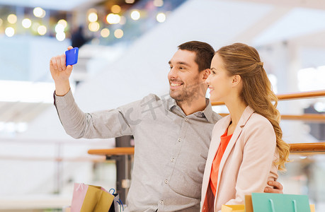 幸福的夫妻在商场里用智能手机自拍