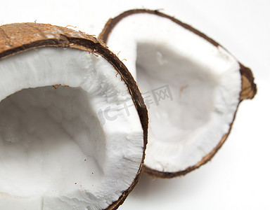 白色光影背景摄影照片_白色背景上带有光影的破裂椰子的特写