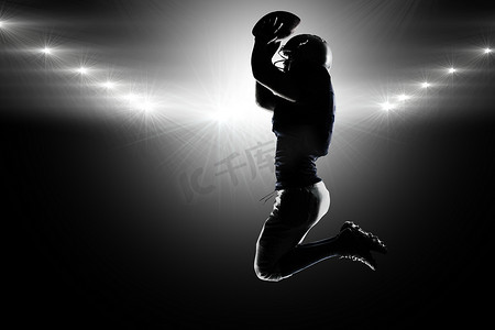 剪影美式足球运动员持球跳跃的合成图像