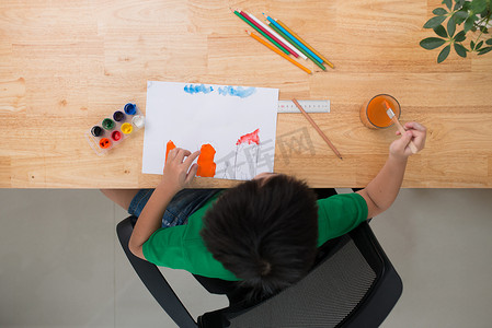 小孩在纸上画画。