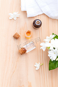 香薰油瓶排列在木制背景板上的茉莉花