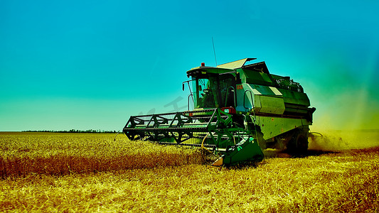 收割机摄影照片_收割机在夏日联合收割小麦。