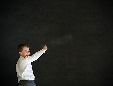 黑板写字摄影照片_打扮成商人的男孩在黑板上写字