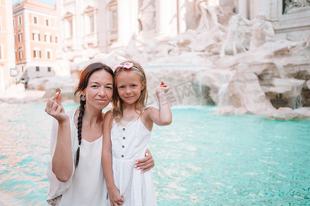 年轻漂亮的女人和小女孩靠近喷泉 Fontana di Trevi