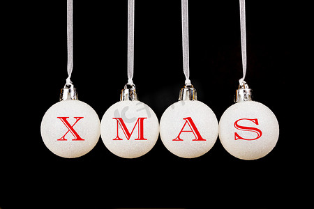 黑色背景上挂着的白色圣诞球上的 word xmas