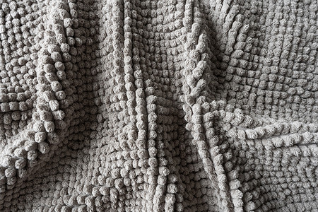 圆地毯花纹摄影照片_由小球制成的灰色毯子的质地。