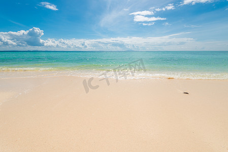 沙滩上的细沙，平静的蔚蓝大海和美丽的云彩