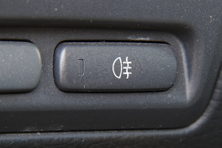 汽车仪表摄影照片_汽车仪表板上的后雾灯开关。