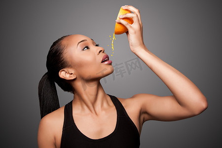 快乐健康的亚洲黑人女性榨橙汁水果