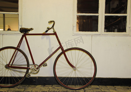 靠在白墙上的单辆旧自行车