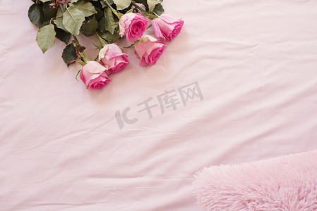 卧室的粉红色床单上有令人惊叹的粉红色玫瑰花框。