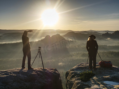 山顶云摄影照片_两名徒步旅行者在山顶拍照和交谈。