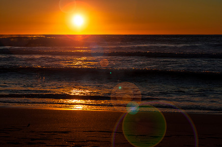 秋天沙滩上的夕阳与镜头光晕