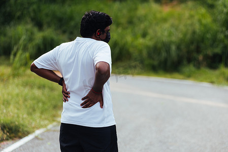 女性腰痛摄影照片_跑步黑人戴手表感觉脊柱腰痛