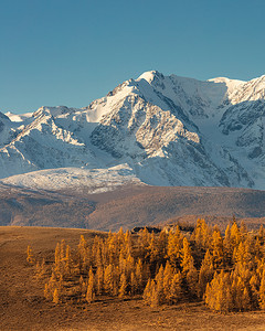 前景是白色雪山和山丘的美丽肖像尺寸照片。