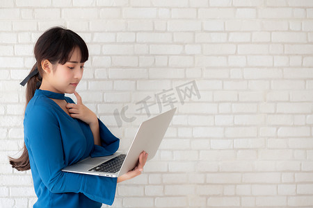 美丽的亚洲年轻女性嬉皮士使用工作笔记本电脑思考