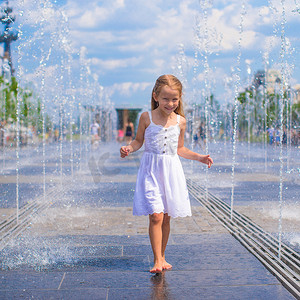 大热天在户外喷泉玩得开心的可爱女孩